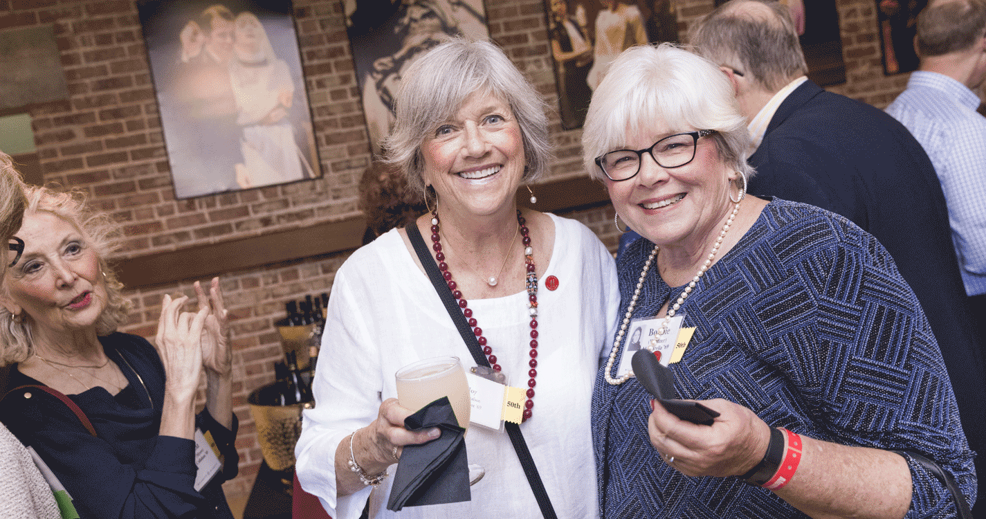 Two alumni at the Alumni Awards reception in the Pelton theater