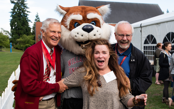 three alumni pose with Blitz the Bearcat