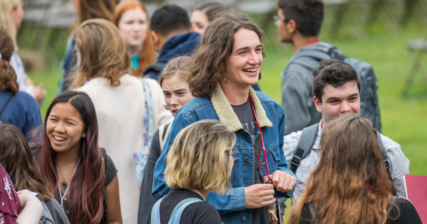 Two students smiles stand out in a crowd gathered on the Quad