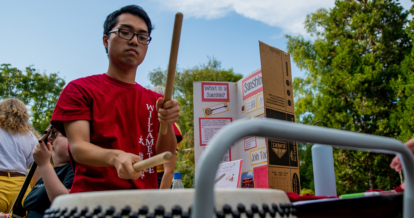 A student plays a drum