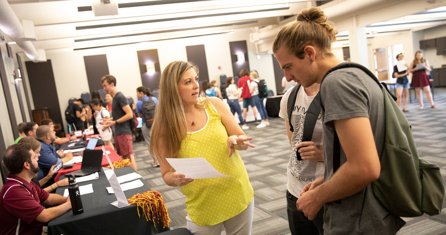 Students talk to representatives from different colleges. 