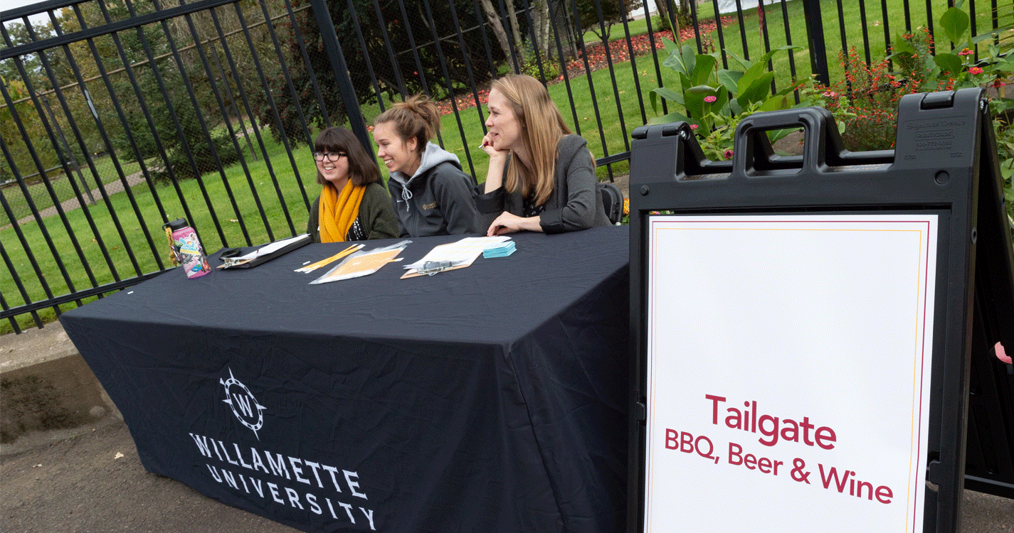 Three people staff the check-in table at 