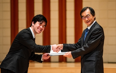 Student shakes TIUA President, Hiroshi Takahashi's hand while receiving their certificate.