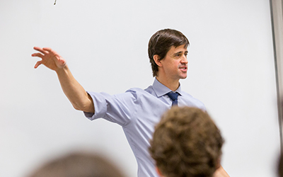 Dave Griffin stands in front of a classroom lecturing