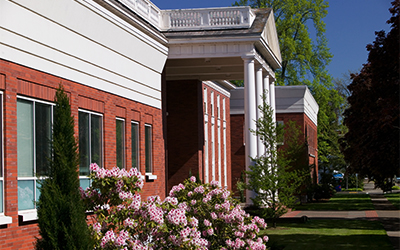 Front of law building with pink rhododendron in bloom