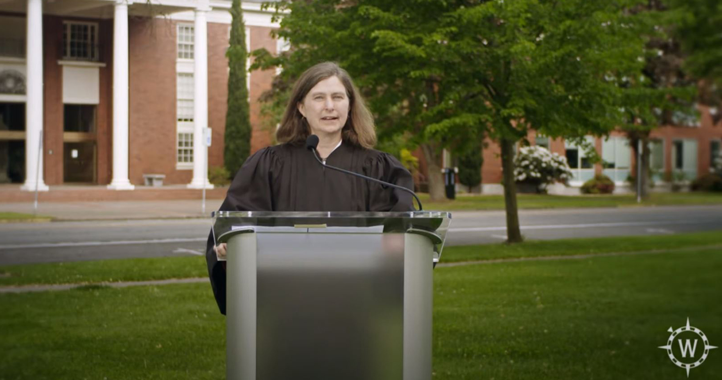 Law speaker at podium in front of law school