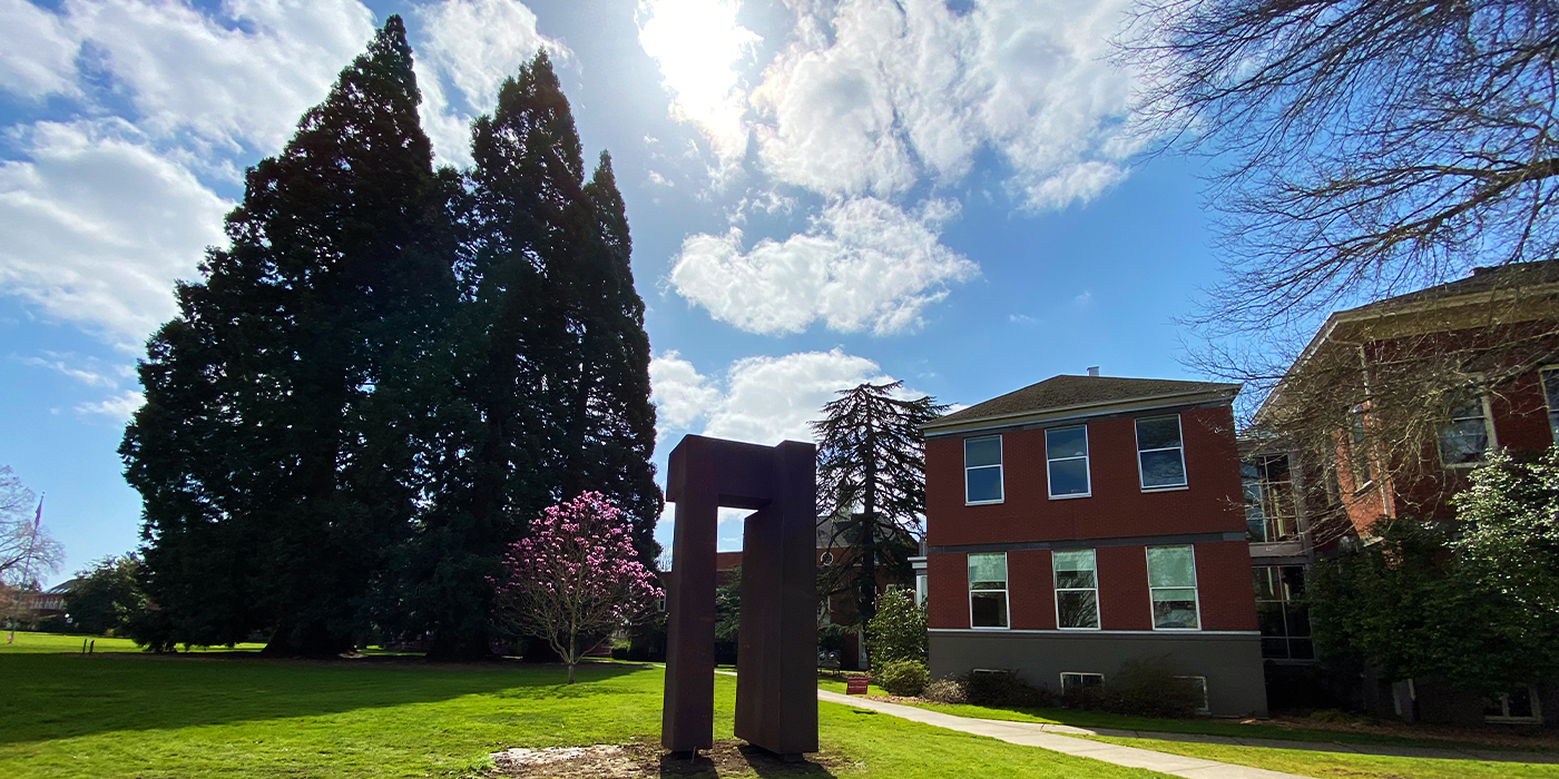 The 15-foot tall sculpture with the Star Trees towering behind it