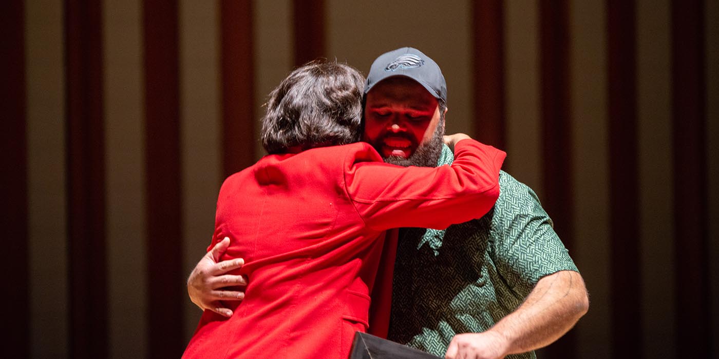 Chaplain hugging a speaker