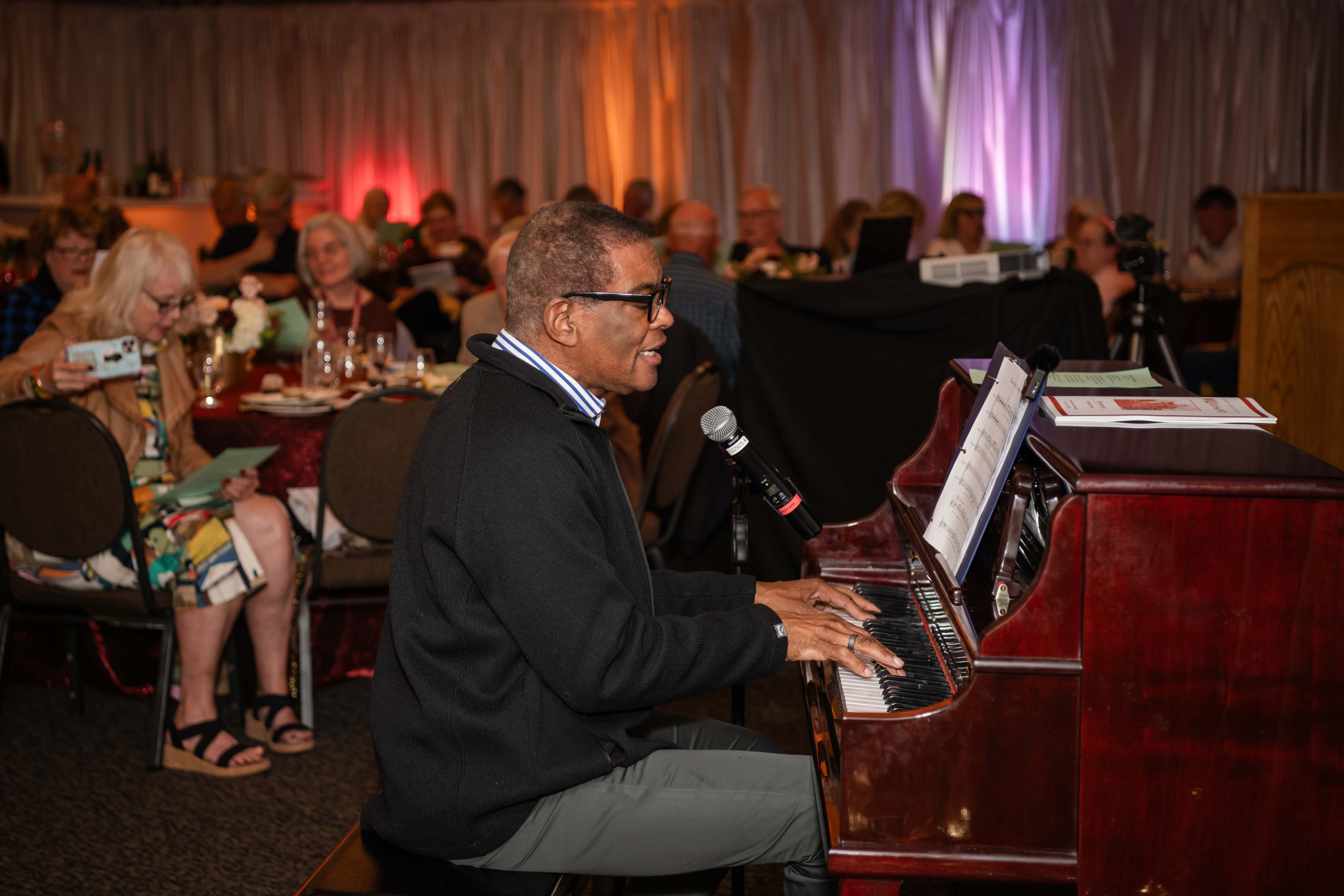 John West BA'73 playing a piano