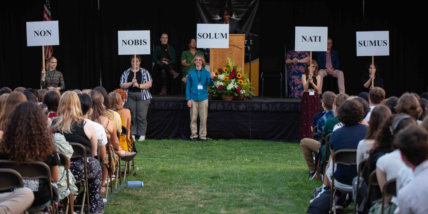 Students hold up signs with Willamette's motto