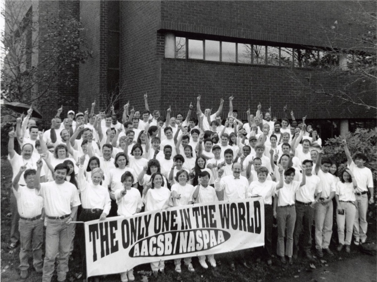 A group of students with sign celebrating dual accreditation