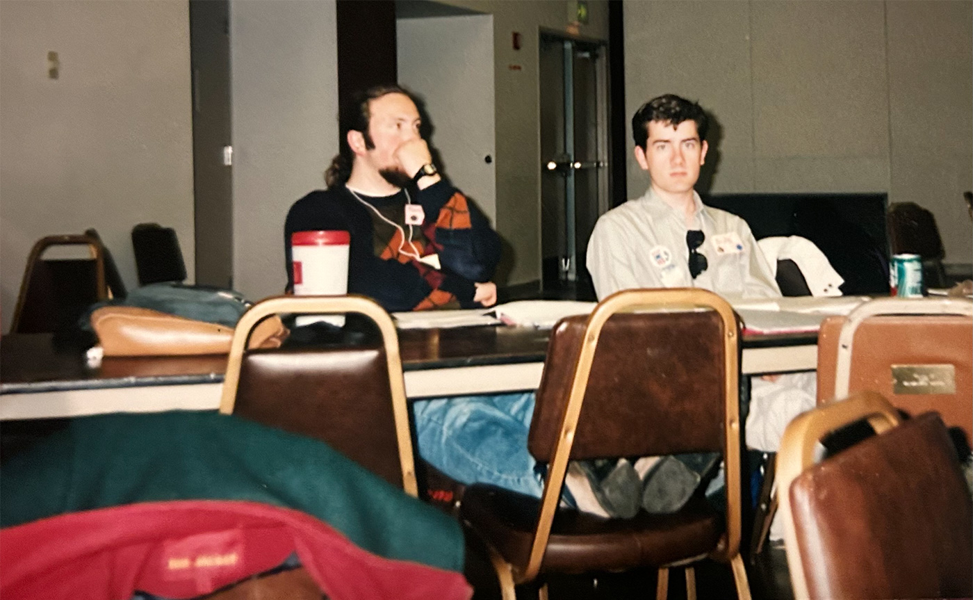 Two students sitting in chairs at a table.