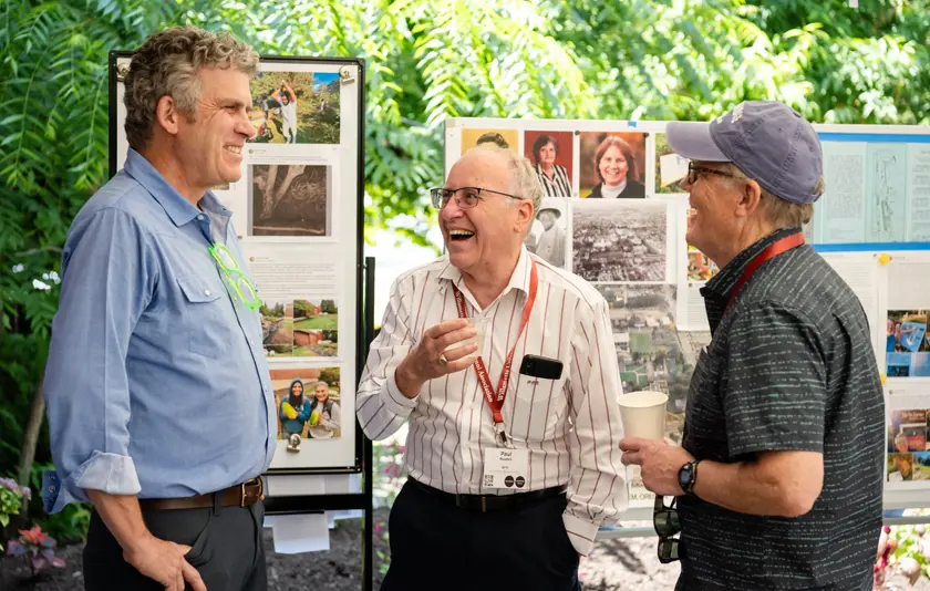 Three men standing in a garden