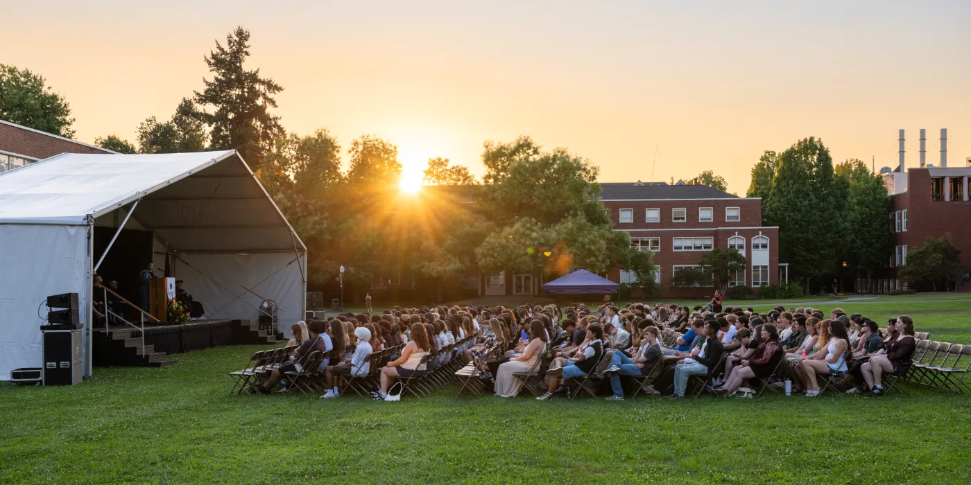 People sitting in chairs in front of a stage