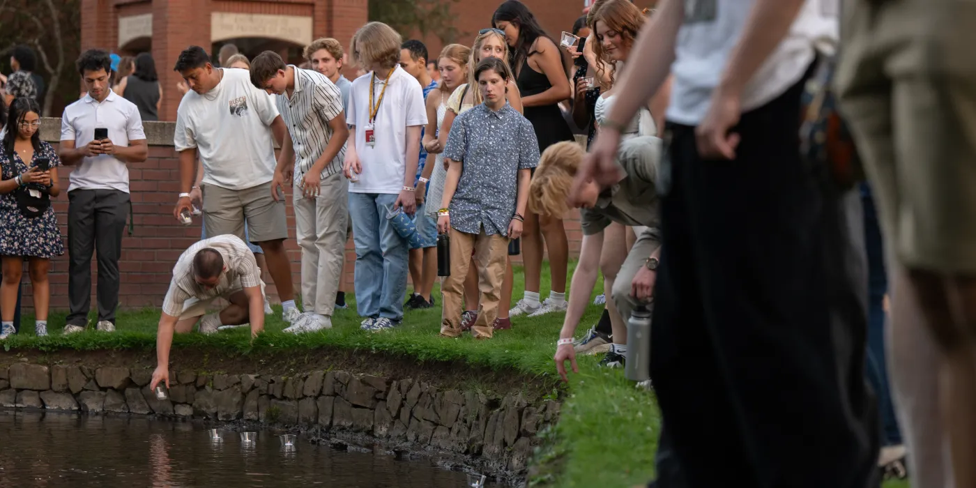 Students putting candles in the Mill Stream