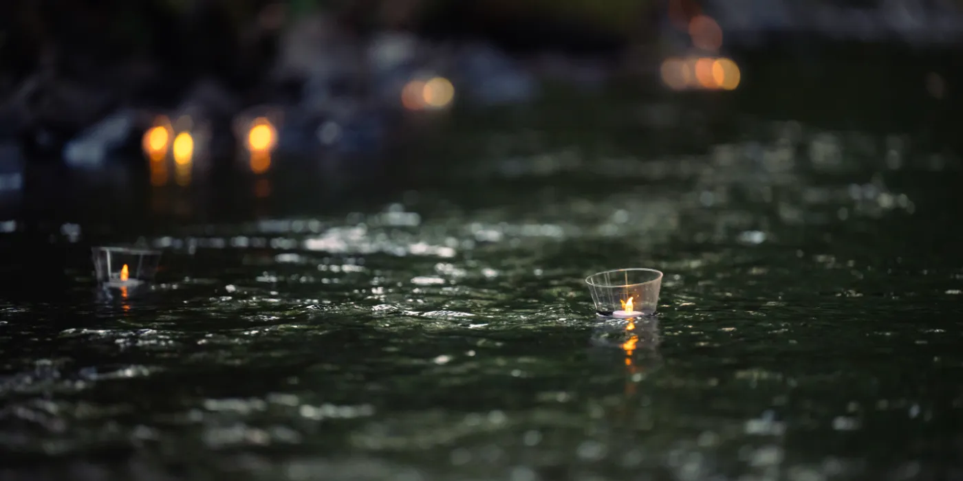 Candles float in the water of the Mill Stream