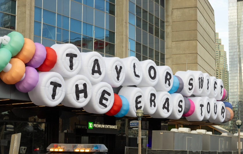 A sign in the style of a friendship bracelet advertising Taylor Swift The Eras Tour