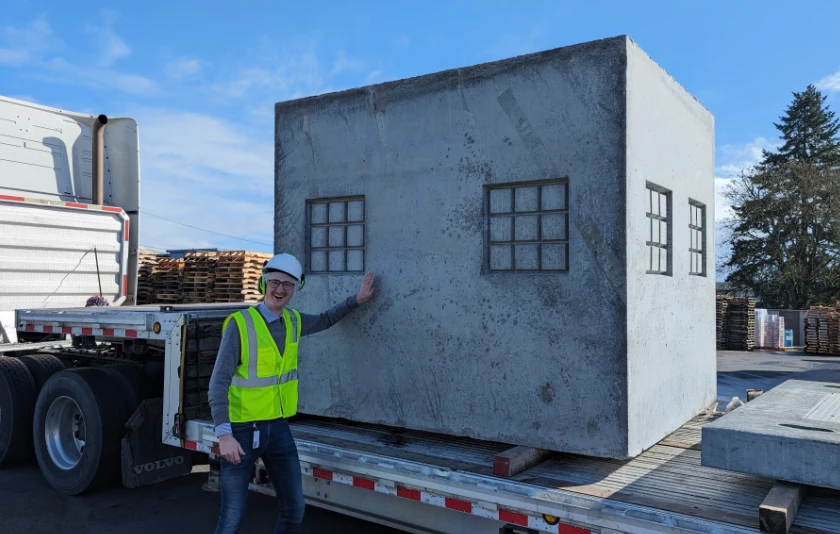 Jadrian posing with a truck and industrial equipment