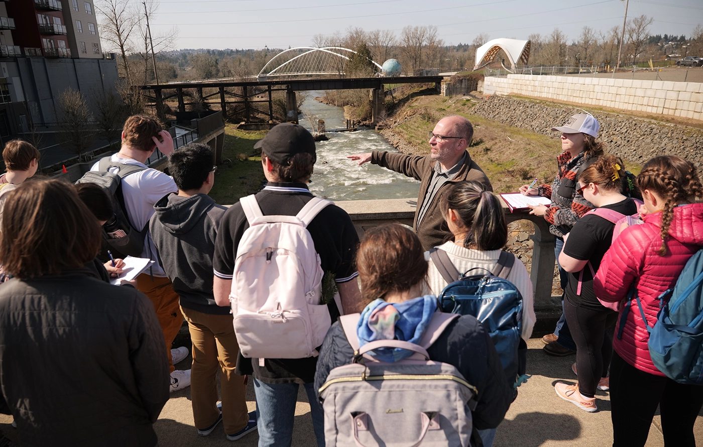 People standing on a bridge looking over a river