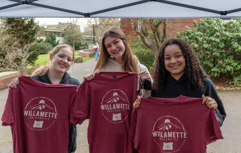 Students holding Willamette shirts