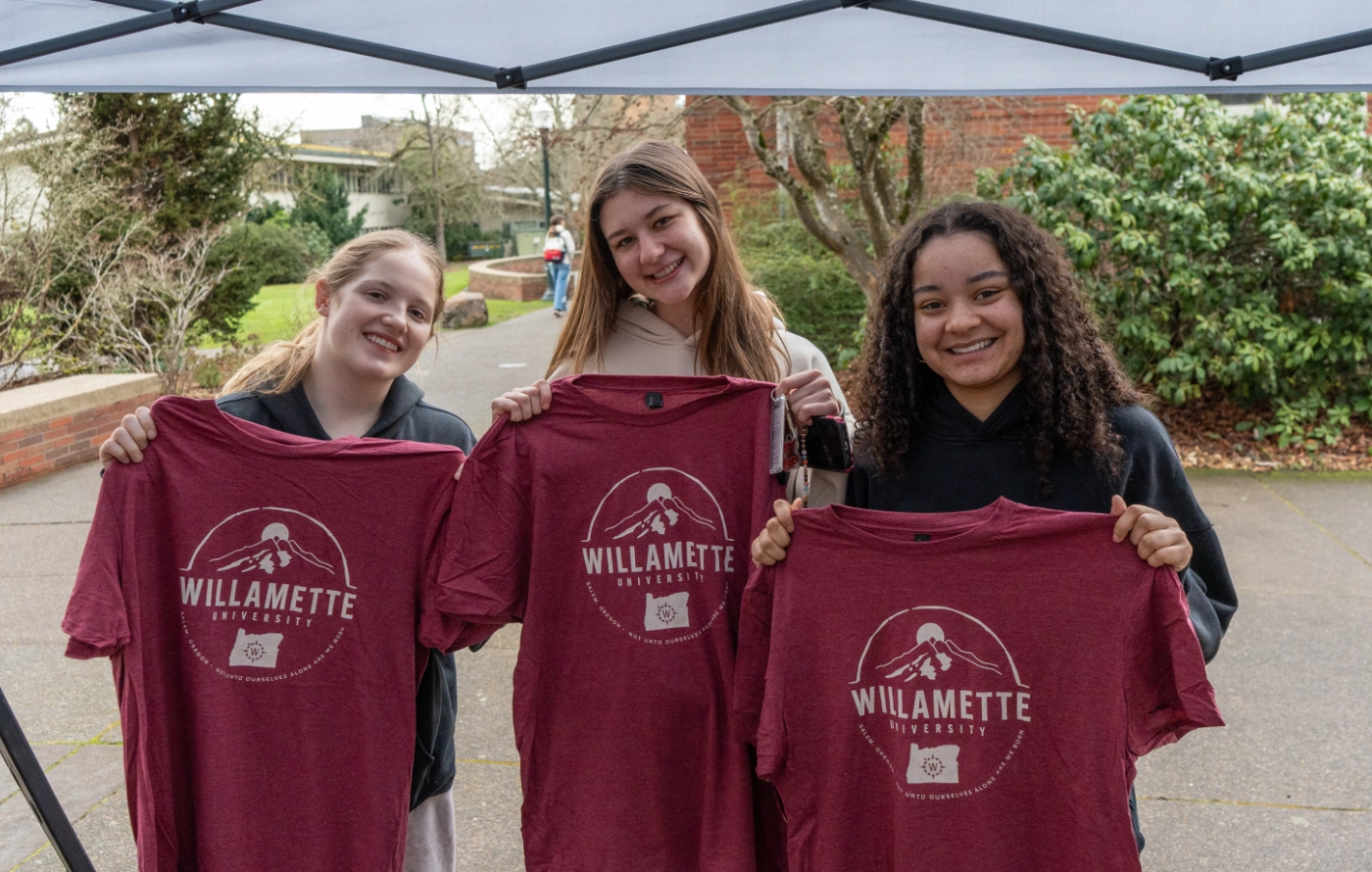 Students holding Willamette shirts