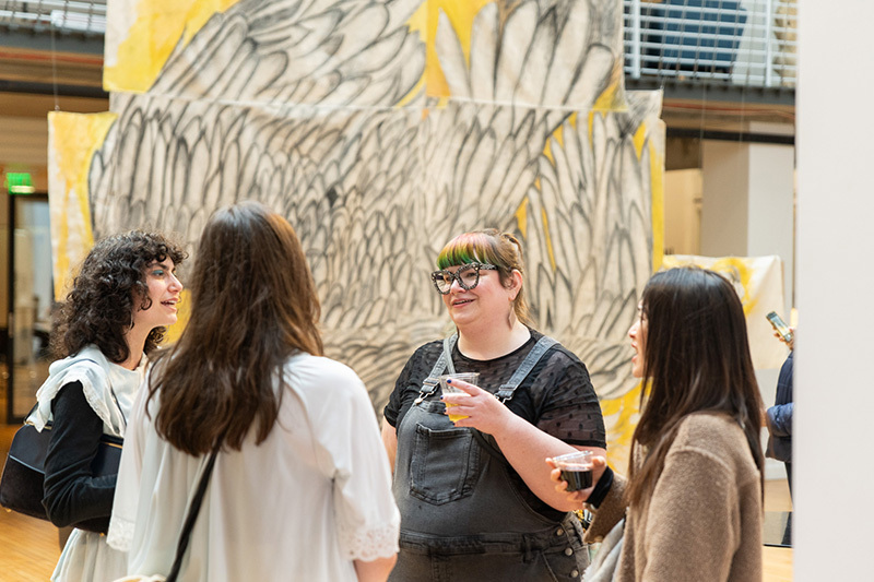 PNCA Low Residency MFA Thesis Exhibition show, students gather in discussion in the atrium