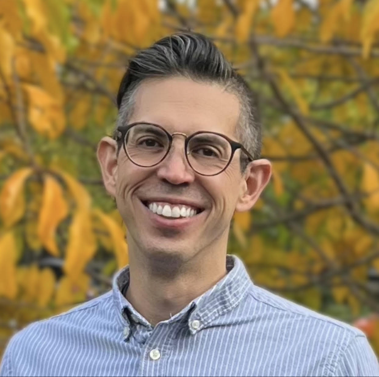 Headshot of Van Cleave in front of yellow leaves.